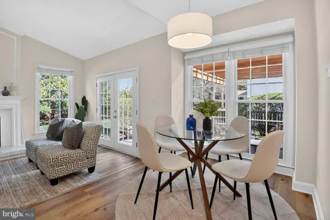 a kitchen with stainless steel appliances a stove top oven a sink dishwasher a refrigerator white cabinets and wooden floor