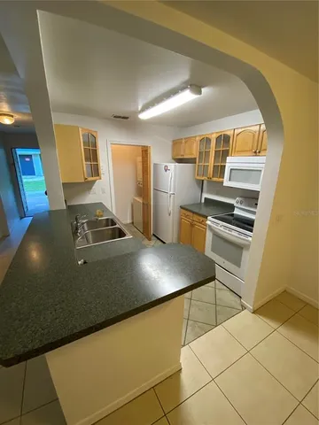 a view of kitchen with furniture and refrigerator