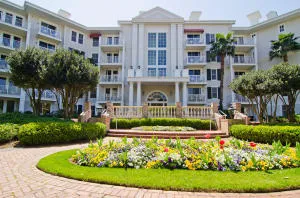 a front view of a residential apartment building with a yard and potted plants