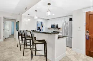 a kitchen with kitchen island a dining table chairs stainless steel appliances and cabinets
