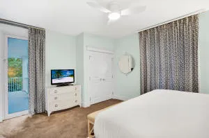a bedroom with a bed and a flat tv screen on dresser