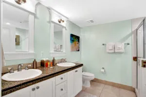 a bathroom with a granite countertop sink a toilet and a mirror