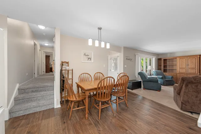 a dining room with furniture a chandelier and wooden floor