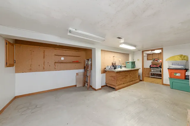 a view of an empty room with cabinet and kitchen view