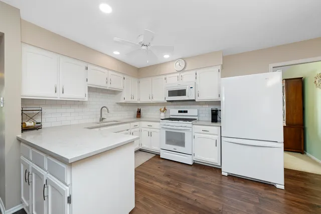 a kitchen with white cabinets stainless steel appliances and sink