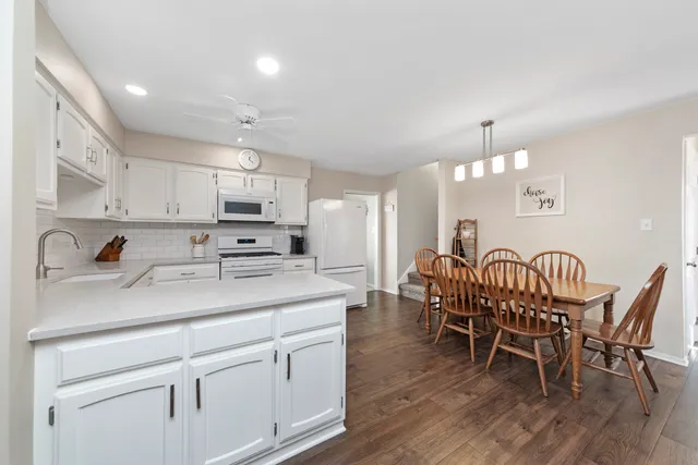 a open kitchen with stainless steel appliances granite countertop a dining table chairs stove a sink and dishwasher