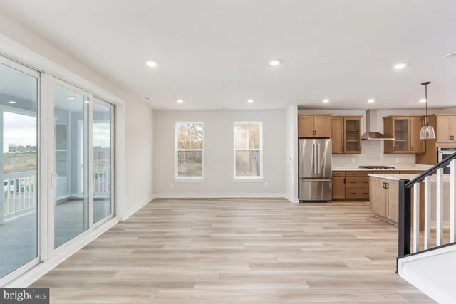 a view of kitchen with stainless steel appliances kitchen island wooden cabinets and refrigerator
