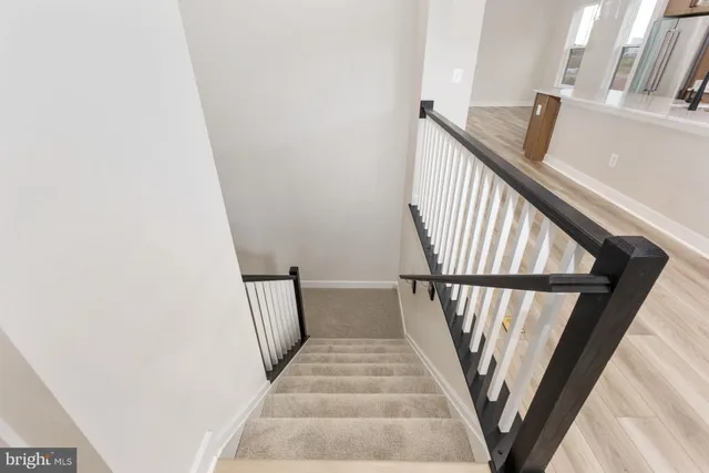 a view of staircase with wooden floor and white walls