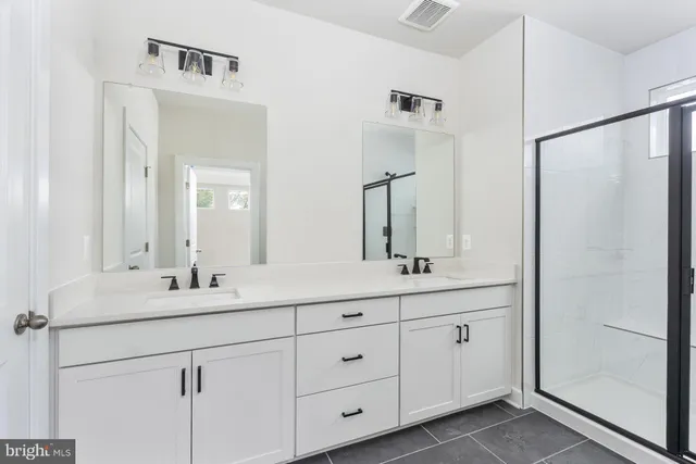 a bathroom with a shower sink and mirror