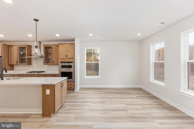 a large kitchen with stainless steel appliances granite countertop a sink a stove and a refrigerator