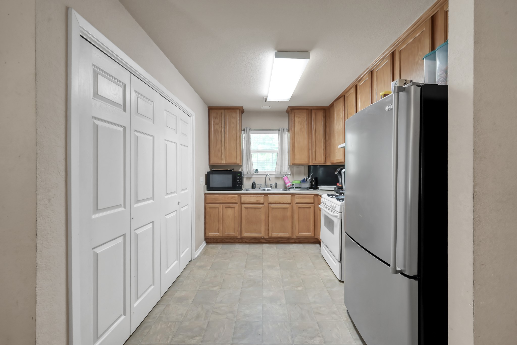 805 Webb Street Conroe, TX 77301 - Photo 11 of 19 a kitchen with white cabinets and refrigerator