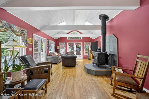 a living room with furniture a flat screen tv and floor to ceiling window