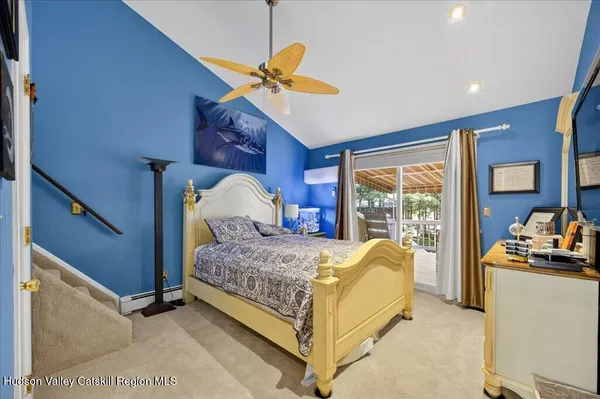 a bedroom with a bed and a flat tv screen on the dresser