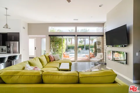 a living room with furniture a flat screen tv and a large window