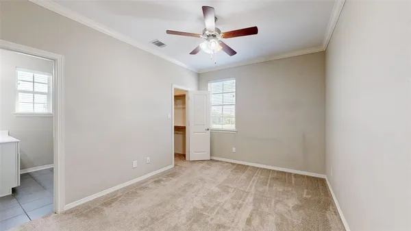 a view of an empty room and chandelier fan