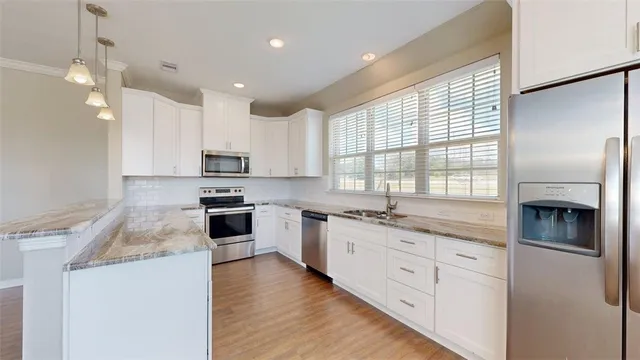 a kitchen with granite countertop white cabinets and white appliances