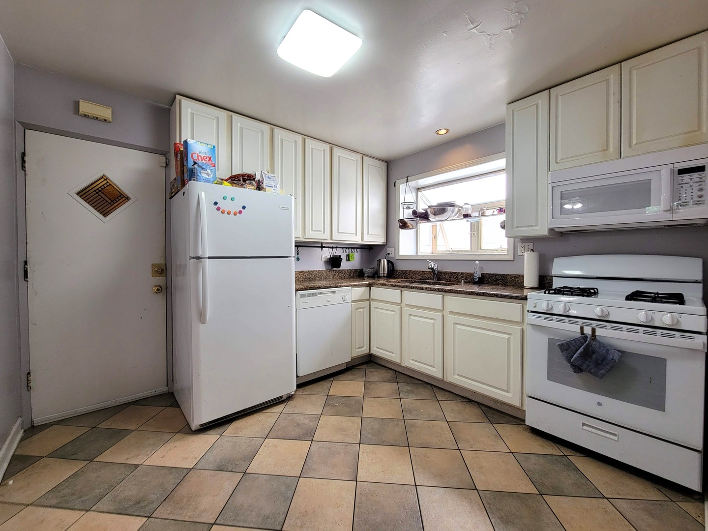 7538 North Ridge Boulevard, Unit 3E Chicago, IL 60645 - Photo 9 of 20 a kitchen with a refrigerator a stove a sink and cabinets