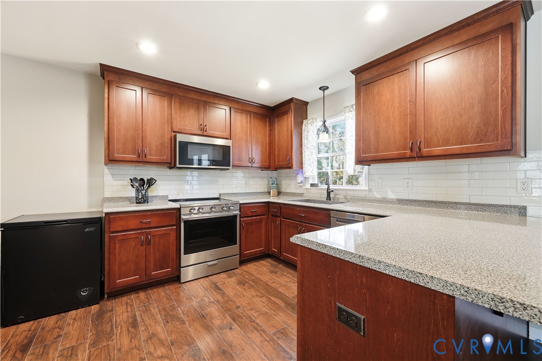 28820 Butler Branch Road Petersburg, VA 23805 - Photo 4 of 27 a kitchen with stainless steel appliances granite countertop wooden cabinets a stove top oven a sink and dishwasher