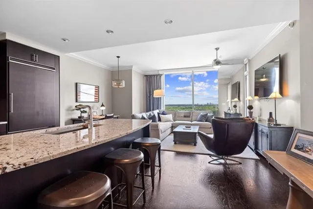 a living room with furniture a large window and dining table
