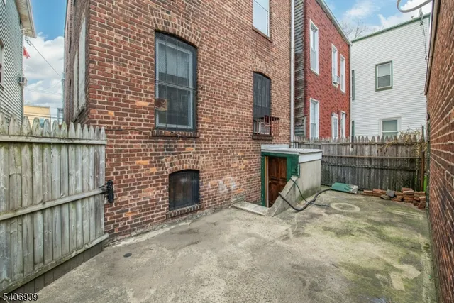 a view of a house with a small yard and wooden fence