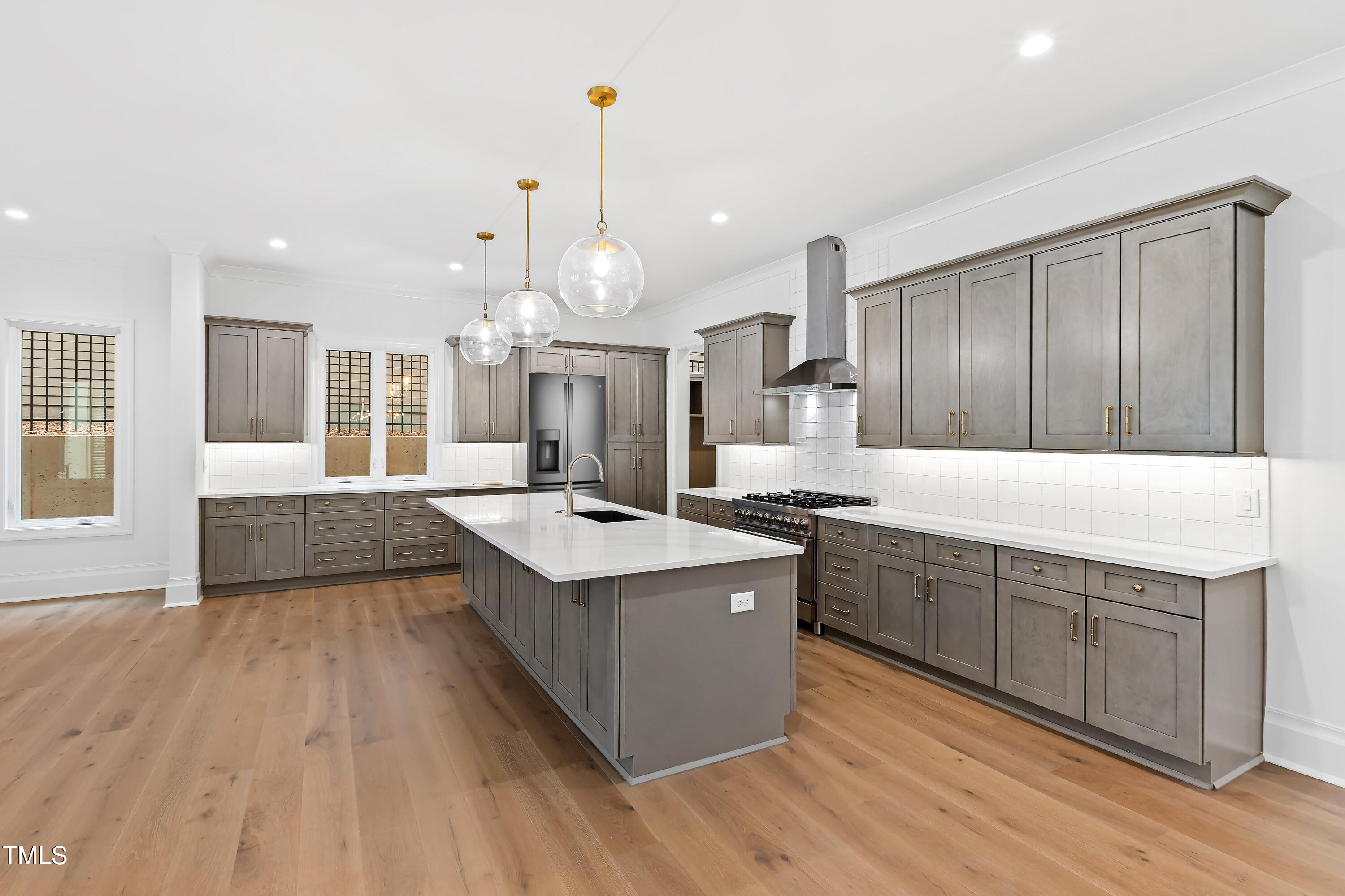 2419 Mayview Road Raleigh, NC 27607 - Photo 13 of 55 a large kitchen with stainless steel appliances kitchen island granite countertop a large counter top and wooden floors