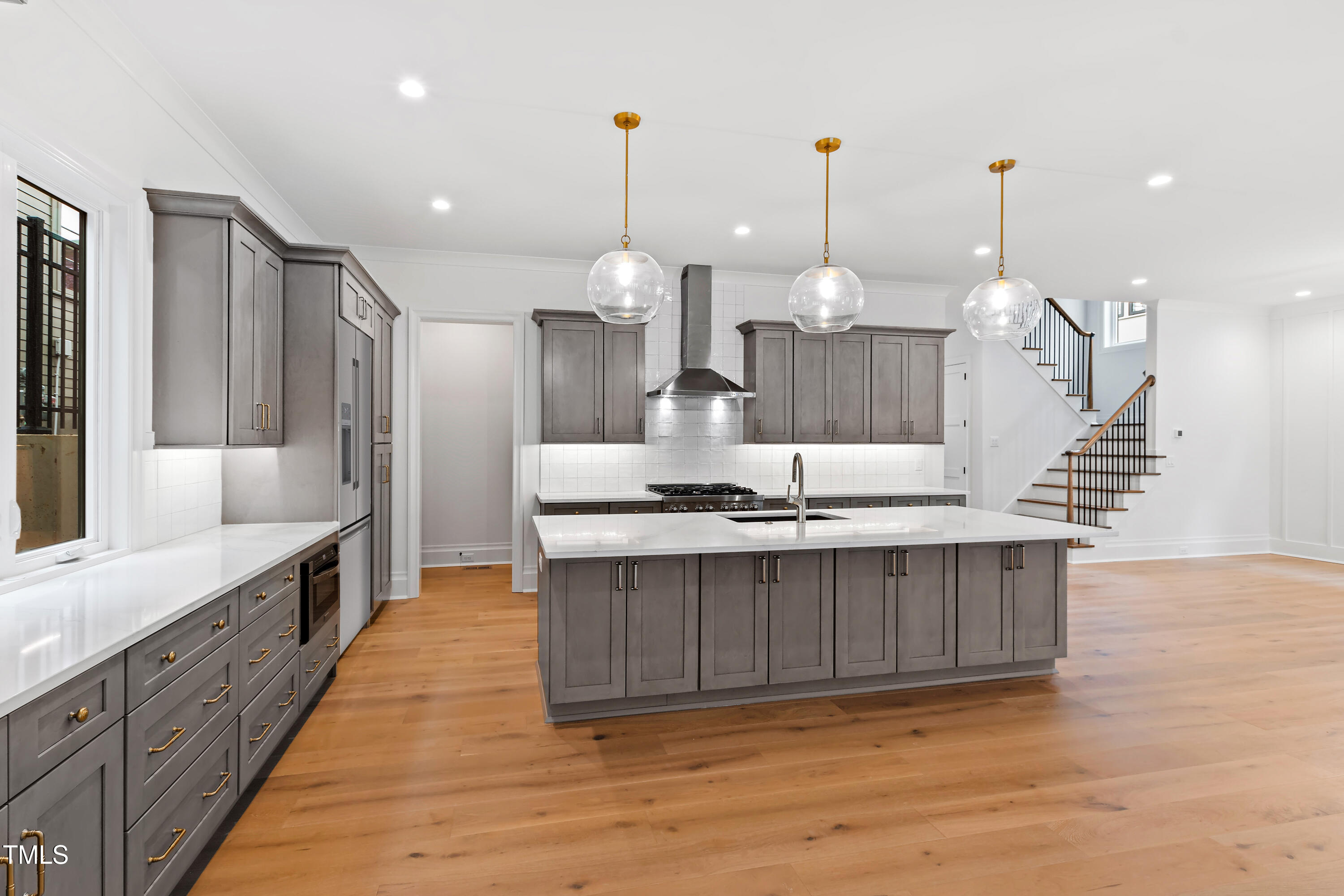2419 Mayview Road Raleigh, NC 27607 - Photo 20 of 55 a large kitchen with kitchen island a island in the center and wooden floor