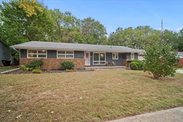 a front view of a house with yard and green space