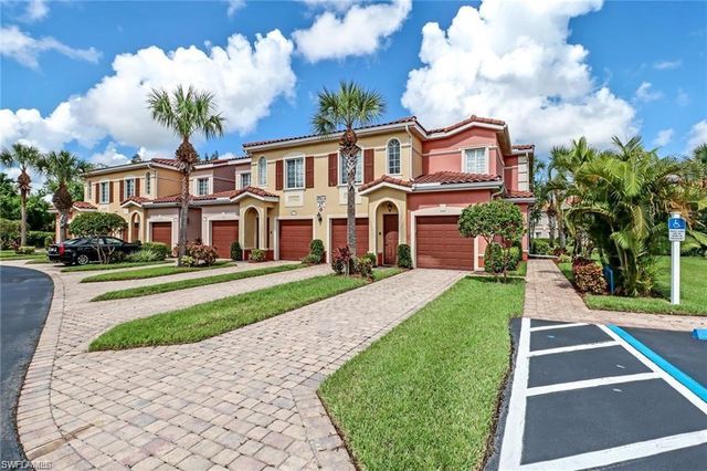a front view of a house with a yard and potted plants