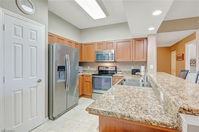 a kitchen with stainless steel appliances granite countertop a refrigerator sink and cabinets