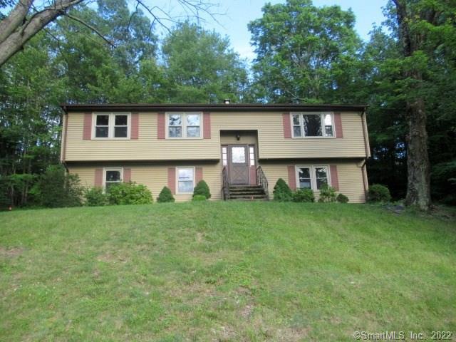 a front view of a house with a yard and trees