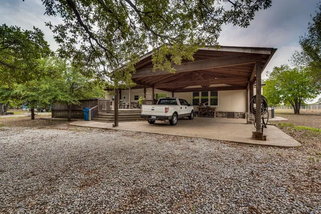 a view of a house with a yard and large tree