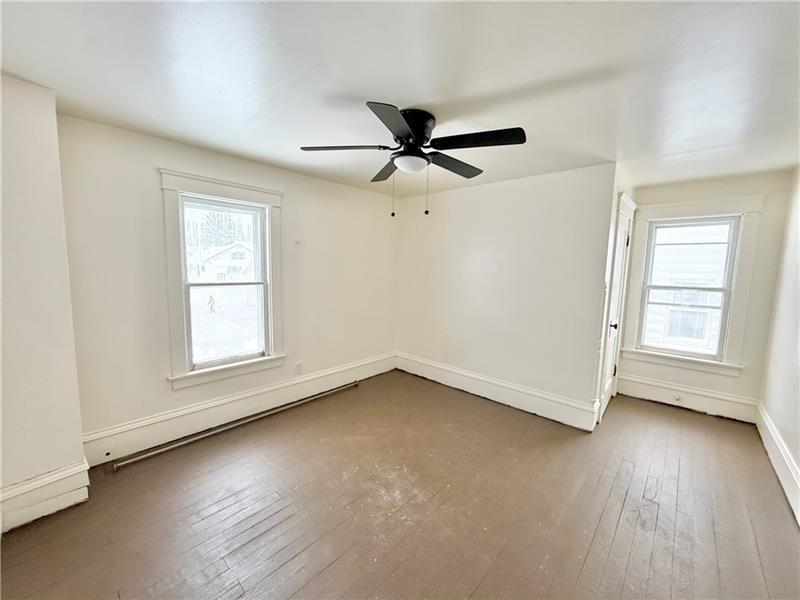 657 North Street Meadville, PA 16335 - Photo 16 of 24 an empty room with wooden floor ceiling fan and windows