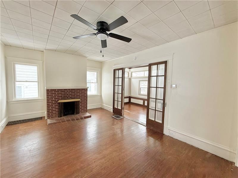 657 North Street Meadville, PA 16335 - Photo 6 of 24 an empty room with wooden floor fireplace and windows