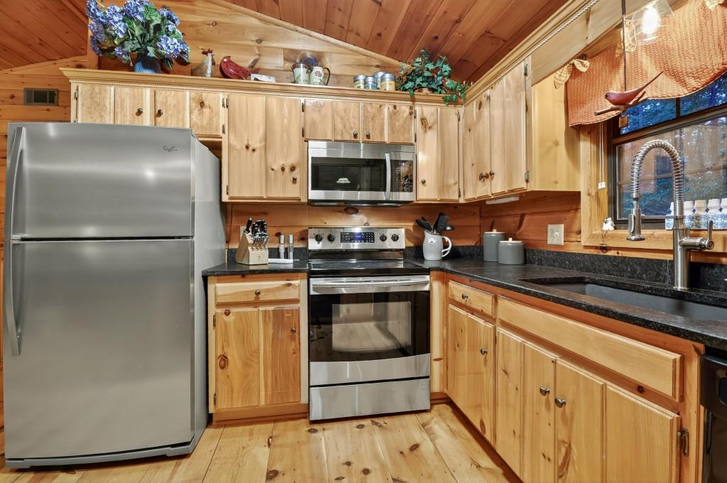 97 Doyle Carder Parkway Blue Ridge, GA 30513 - Photo 17 of 49 a kitchen with stainless steel appliances granite countertop a refrigerator a stove a sink and white cabinets with wooden floor