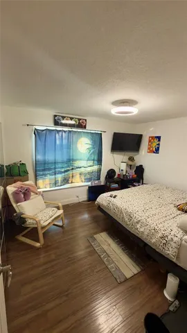 a bedroom with a bed window and view of living room