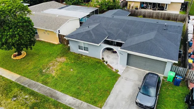 an aerial view of a house with garden space and street view