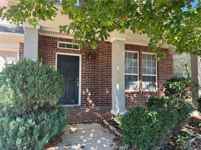 a front view of a house with plants