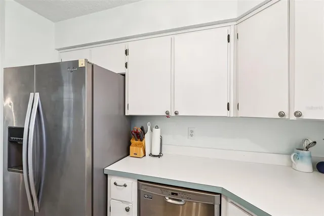 a kitchen with stainless steel appliances a refrigerator and a cabinets