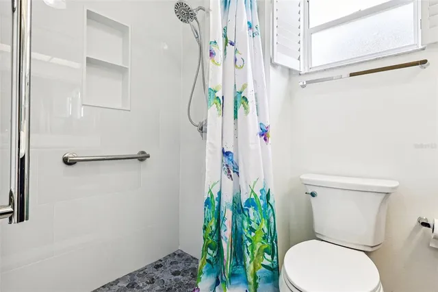 a white toilet sitting next to a shower