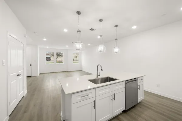 a kitchen with white cabinets a sink and dishwasher