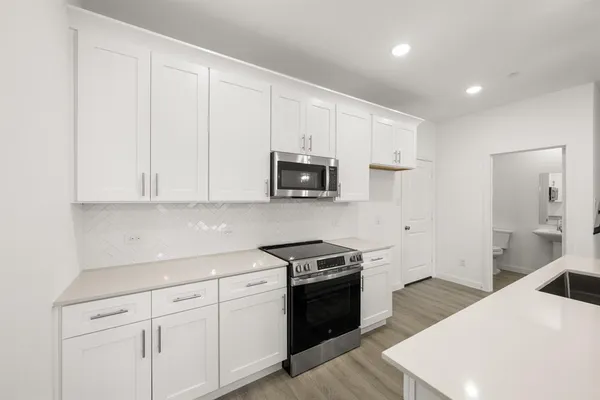 a kitchen with white cabinets and stainless steel appliances
