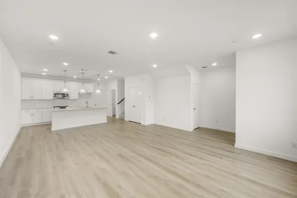 a view of kitchen with kitchen island white cabinets and wooden floor