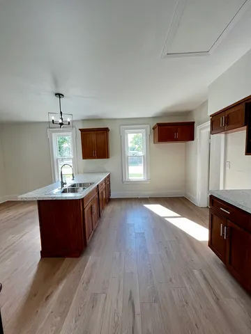 a kitchen with stainless steel appliances granite countertop a stove a sink and a wooden floors
