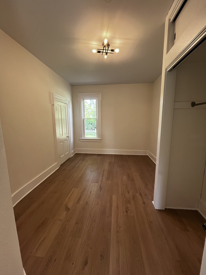 403 Uncas Street Tonica, IL 61370 - Photo 19 of 30 an empty room with wooden floor and windows