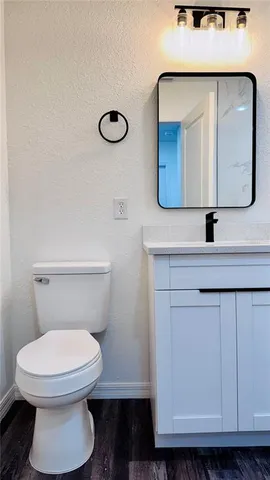 a bathroom with a toilet a sink and mirror