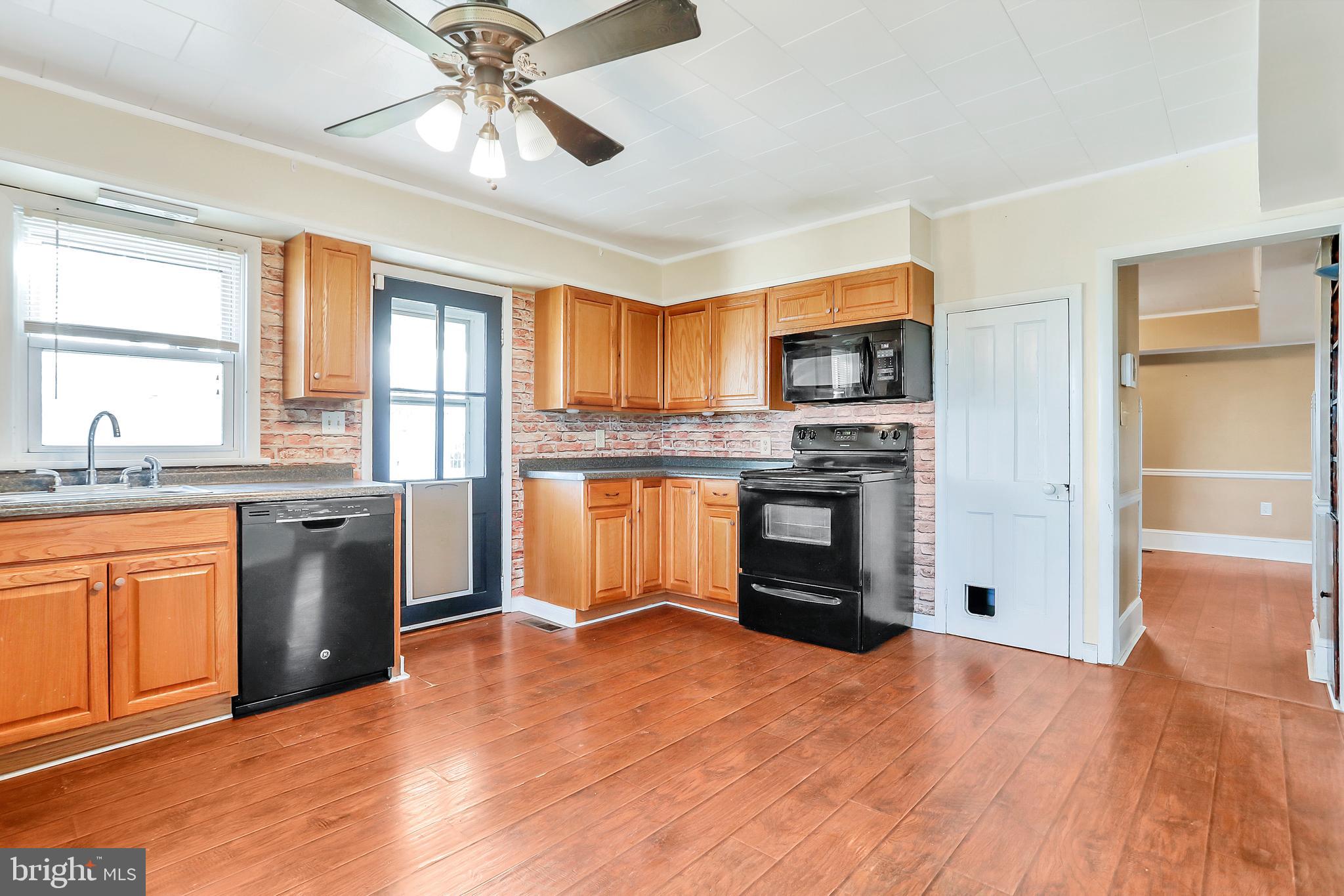 13837 Big Pool Road Clear Spring, MD 21722 - Photo 10 of 57 a kitchen with stainless steel appliances granite countertop a refrigerator a stove top oven a sink and dishwasher with wooden floor