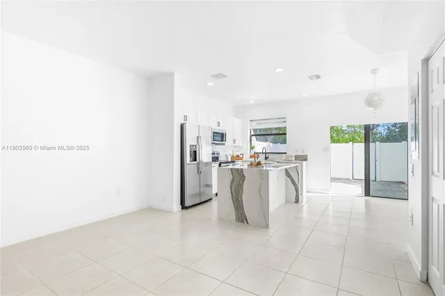 a view of kitchen with furniture and refrigerator
