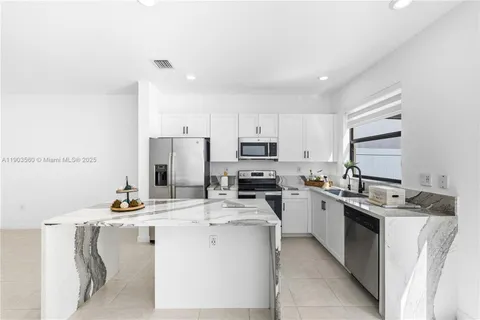 a kitchen with kitchen island a sink stove and refrigerator