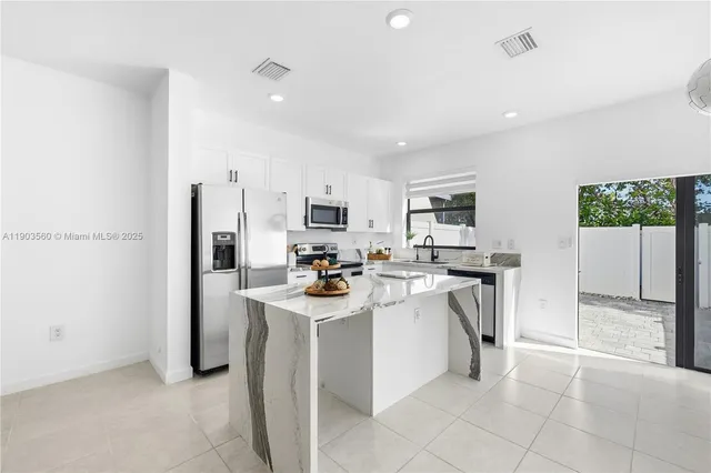 a kitchen with appliances a sink a counter top space and cabinets