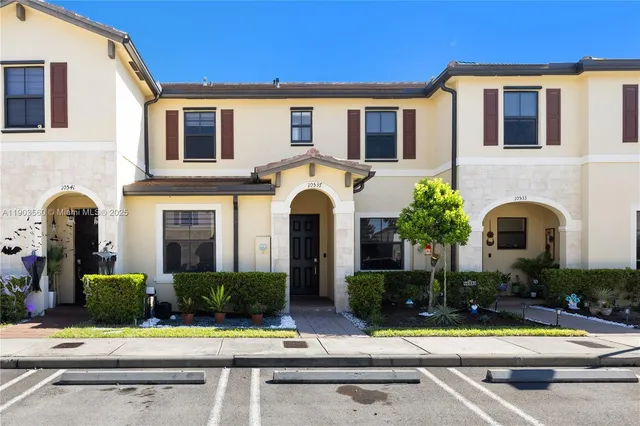 a front view of a house with garden and plants